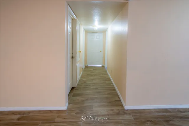 a view of a hallway with wooden floor