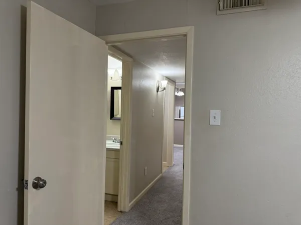a view of a hallway with wooden floor