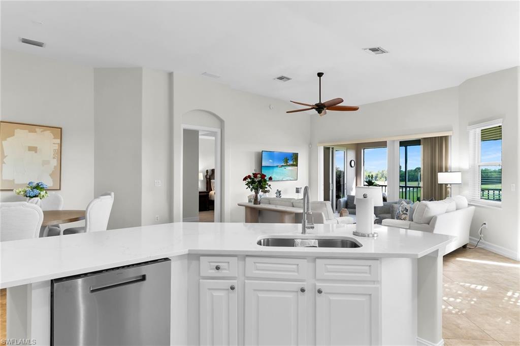 1286 Rialto Way, Unit 9202 Naples, FL 34114 - Photo 7 of 49 Open-concept, fully updated kitchen with brand-new quartz countertops, updated cabinetry, stainless steel appliances, and an expansive island—opening to beautiful, light-filled views beyond.