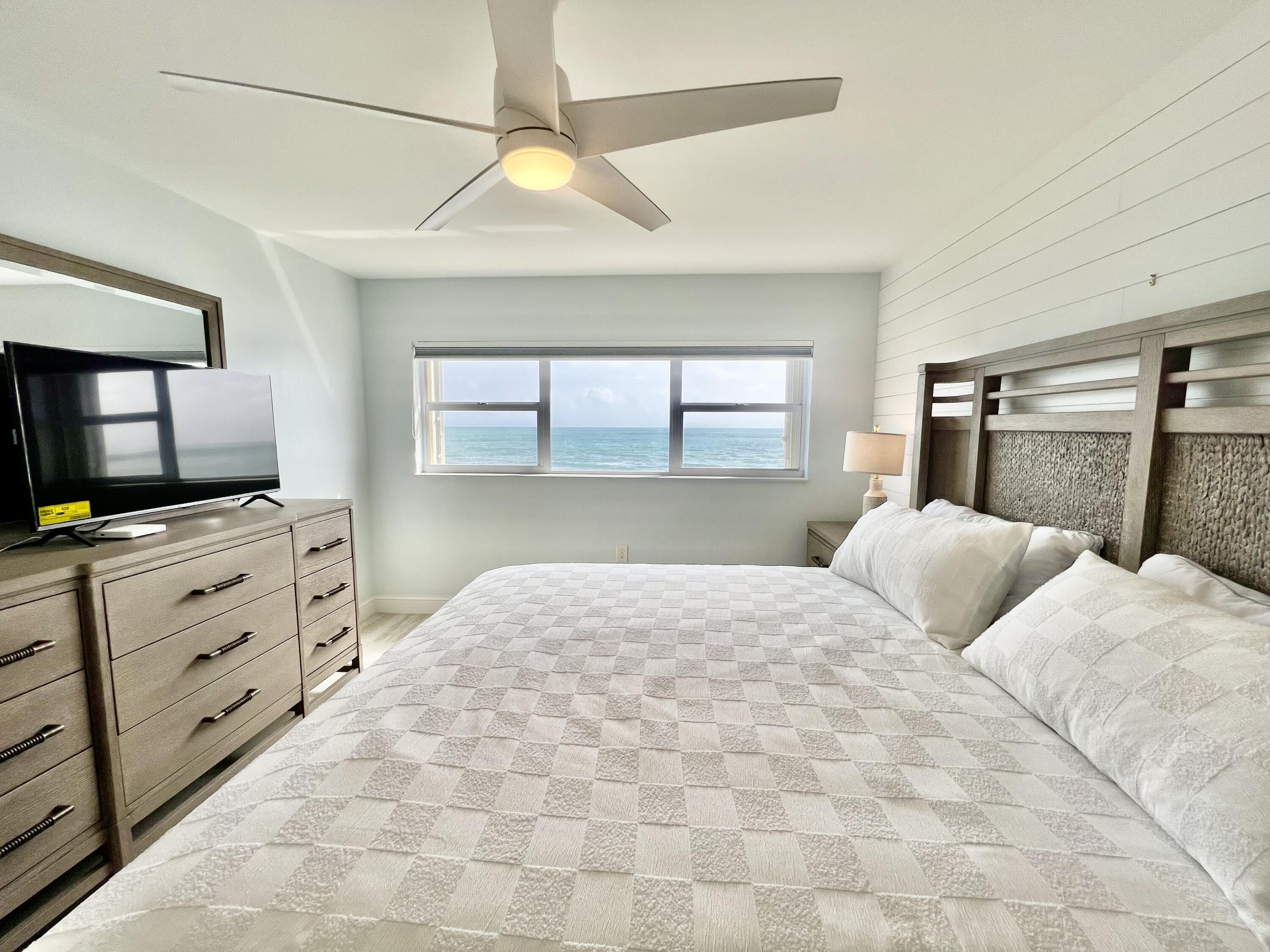 7410 South Ocean Drive, Unit 505 Jensen Beach, FL 34957 - Photo 11 of 33 a bedroom with a large bed and a flat tv screen on dresser