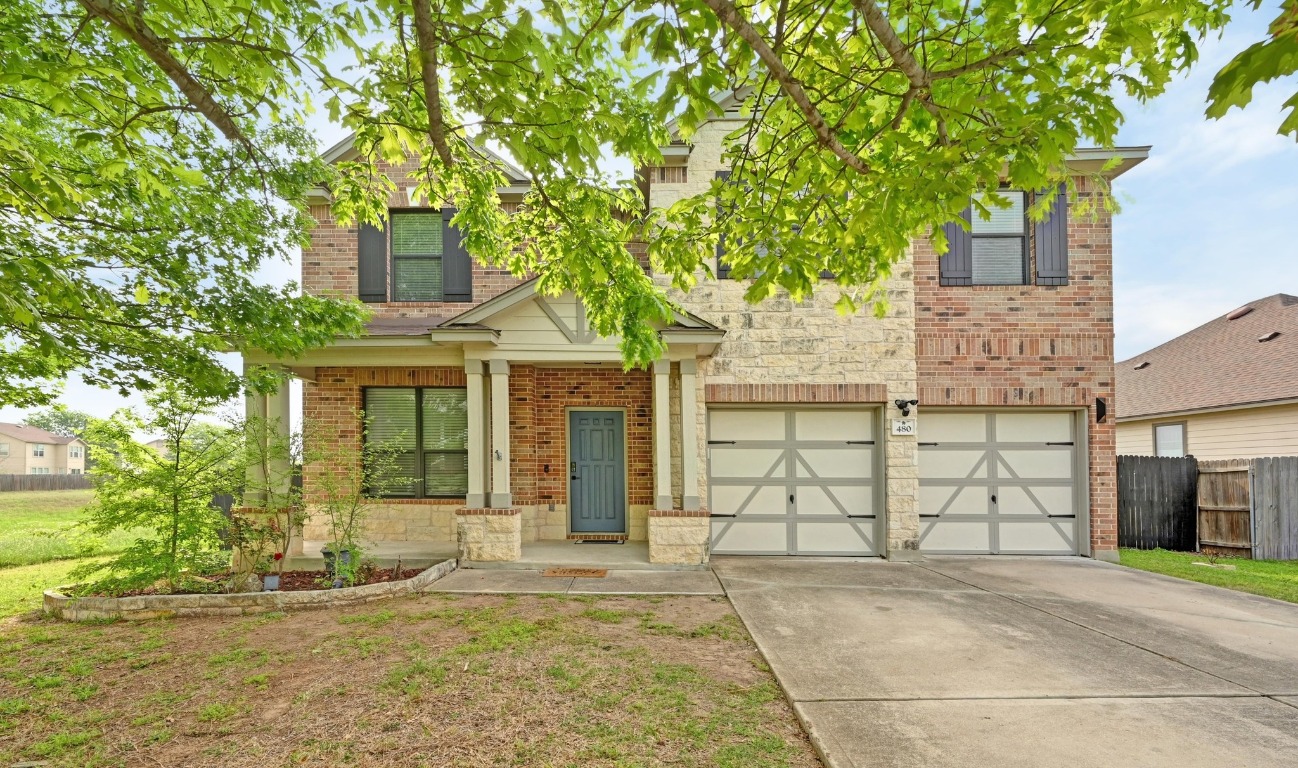 a front view of a house with a tree