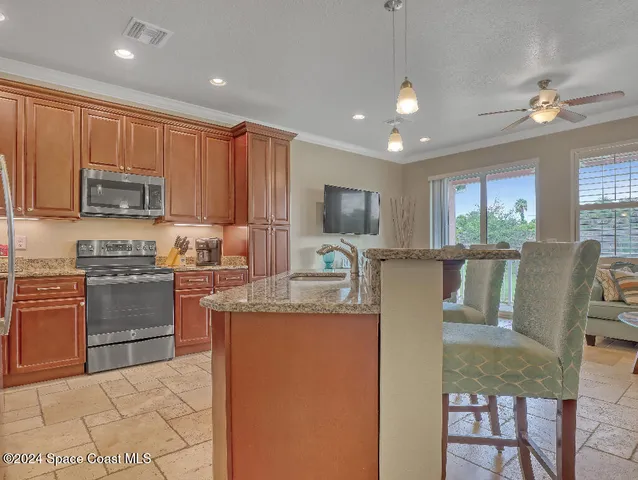 a kitchen with kitchen island granite countertop appliances cabinets and a sink