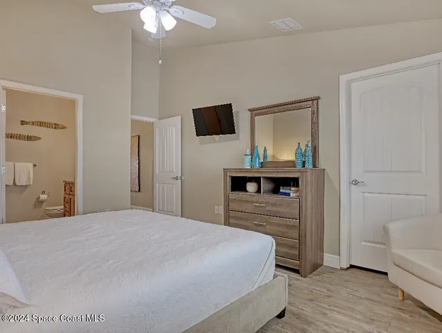 a bedroom with a bed and a flat tv screen on dresser