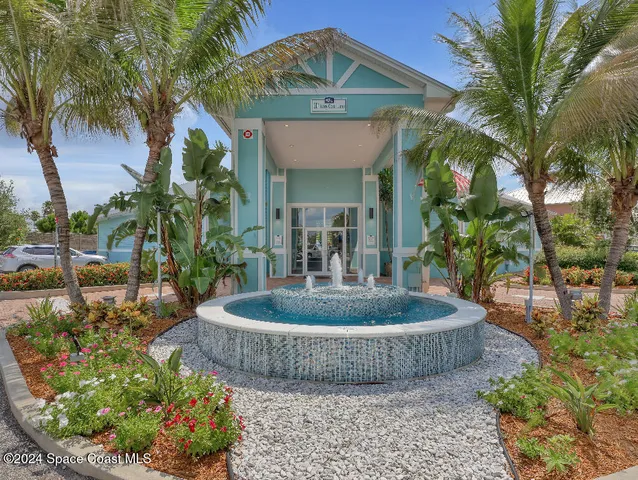 a view of a house with a fountain and potted plants