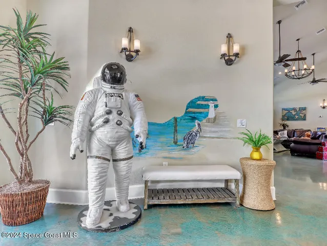 a spacious bedroom with furniture and a chandelier