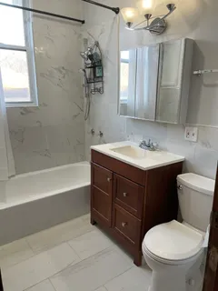 a bathroom with a sink toilet vanity and shower