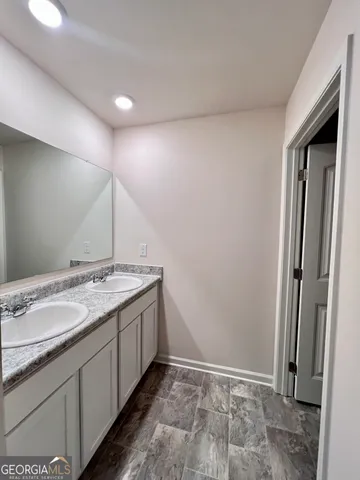 a bathroom with a granite countertop sink and a mirror