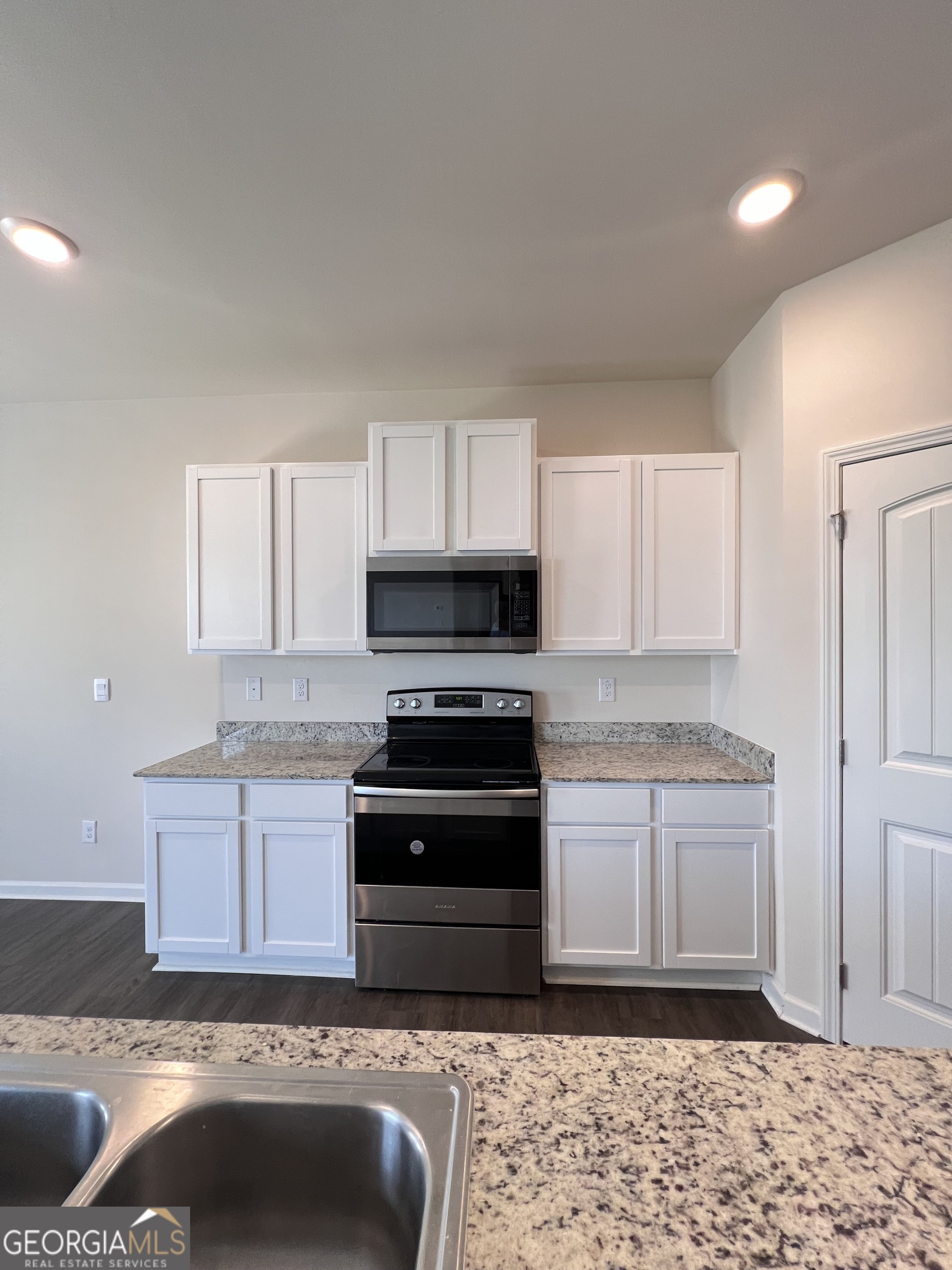 393 Walnut Grove Way Pendergrass, GA 30567 - Photo 5 of 22 a kitchen with stainless steel appliances granite countertop a stove a sink and a microwave