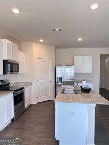 a kitchen with stove a sink and refrigerator