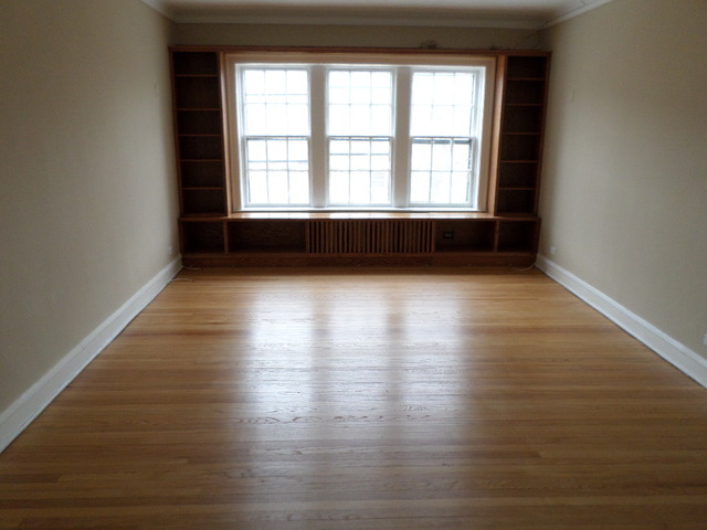 1011 Hull Terrace, Unit 22 Evanston, IL 60202 - Photo 2 of 10 a view of an empty room with wooden floor and a window
