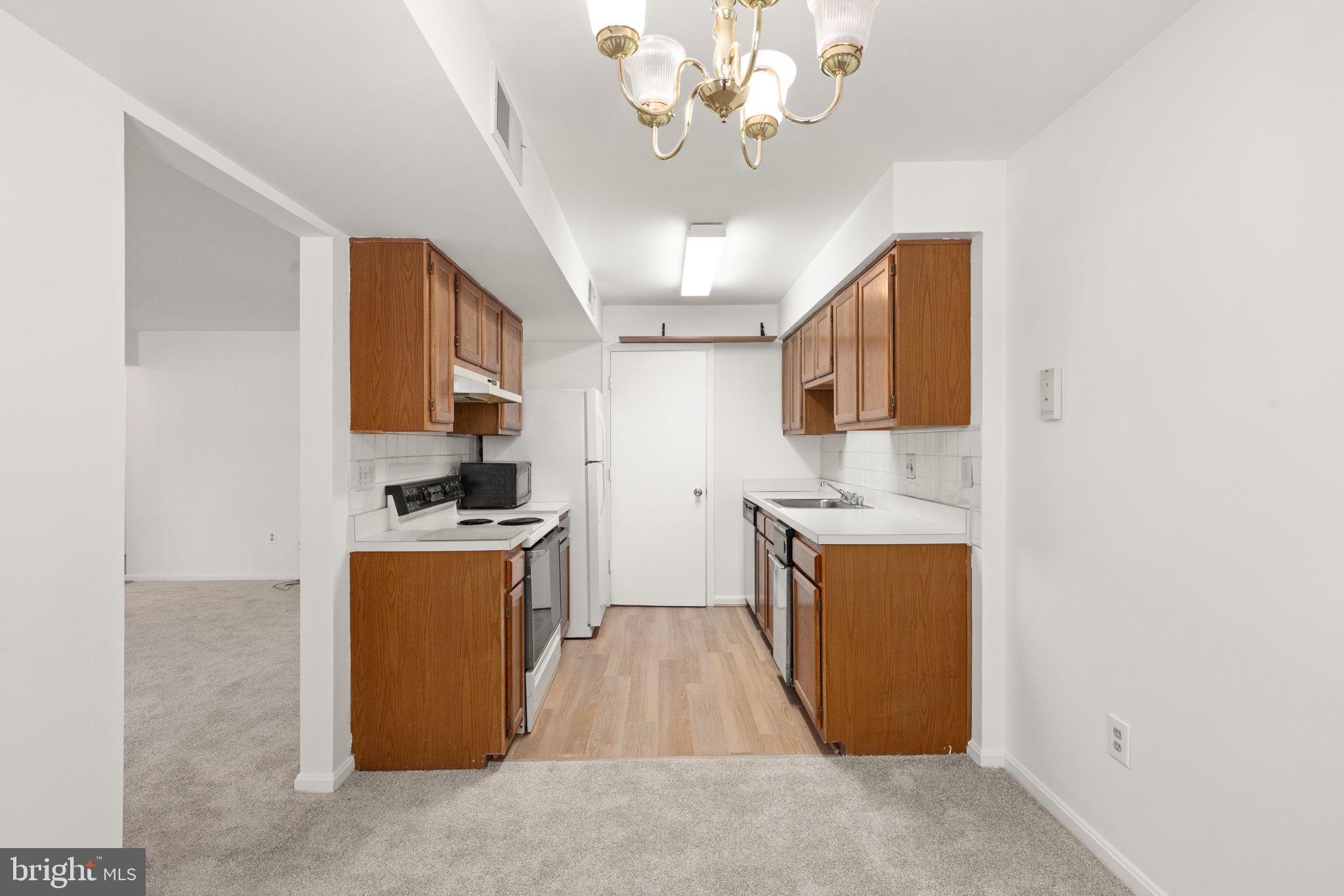 2407 Normandy Square Place, Unit C Silver Spring, MD 20906 - Photo 11 of 19 a kitchen with stainless steel appliances granite countertop a sink stove and refrigerator