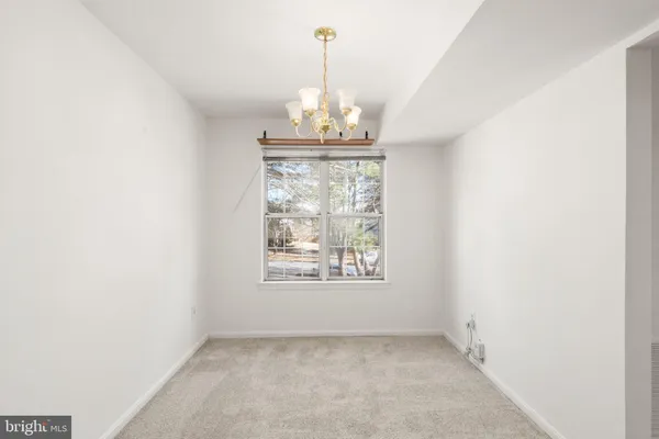 an empty room with a windows and chandelier