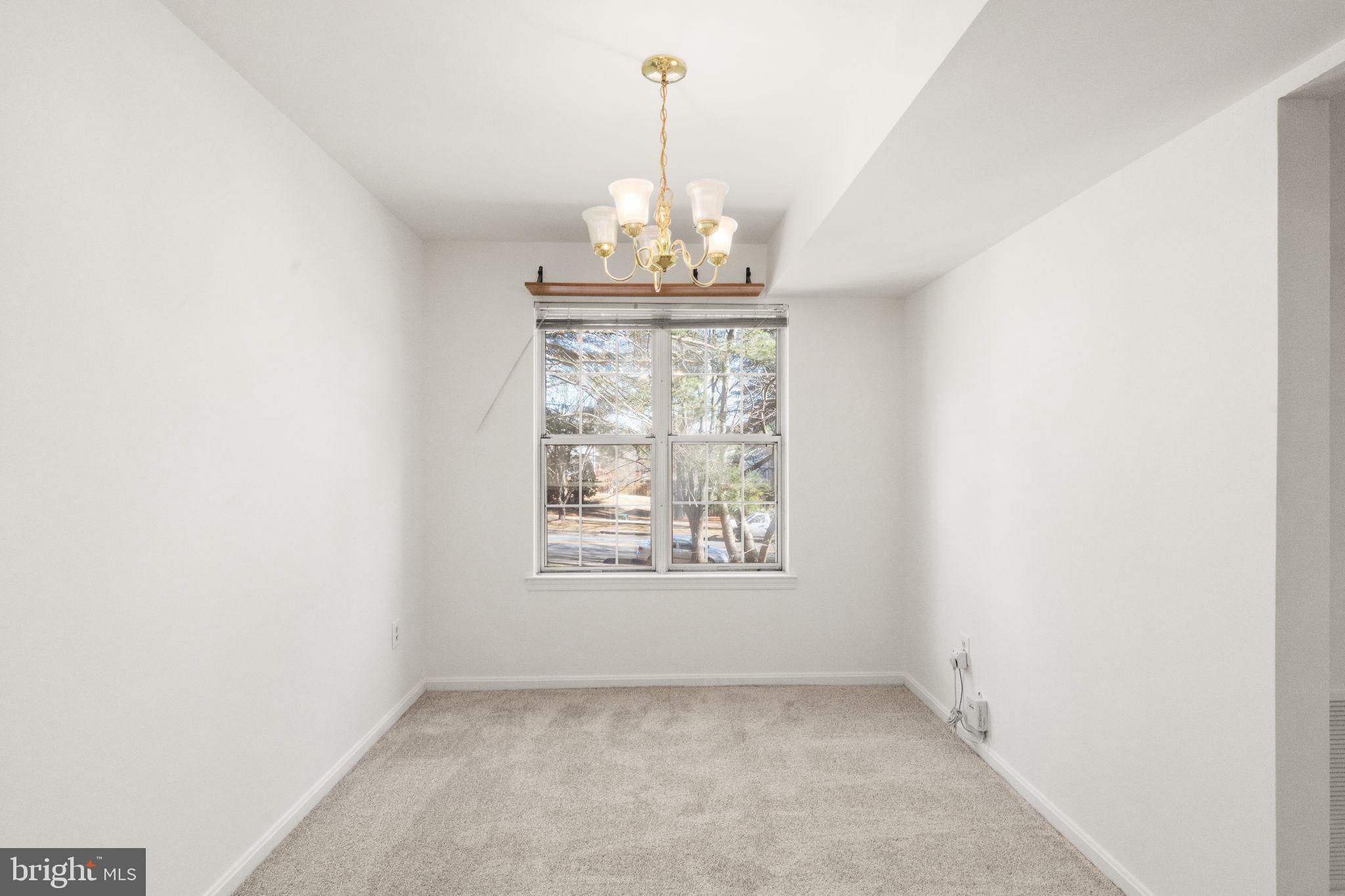 2407 Normandy Square Place, Unit C Silver Spring, MD 20906 - Photo 13 of 19 an empty room with a windows and chandelier