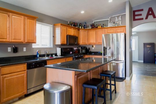 1013 Sims Street Ridgecrest, CA 93555 - Photo 9 of 33 a kitchen with stainless steel appliances granite countertop a sink a stove and a refrigerator