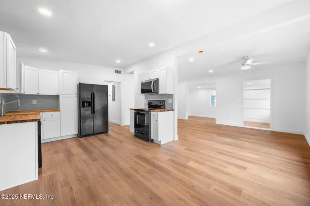 a kitchen with stainless steel appliances a refrigerator and a stove top oven
