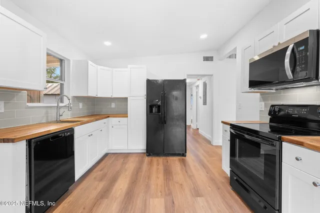 a kitchen with a sink a microwave a refrigerator and cabinets
