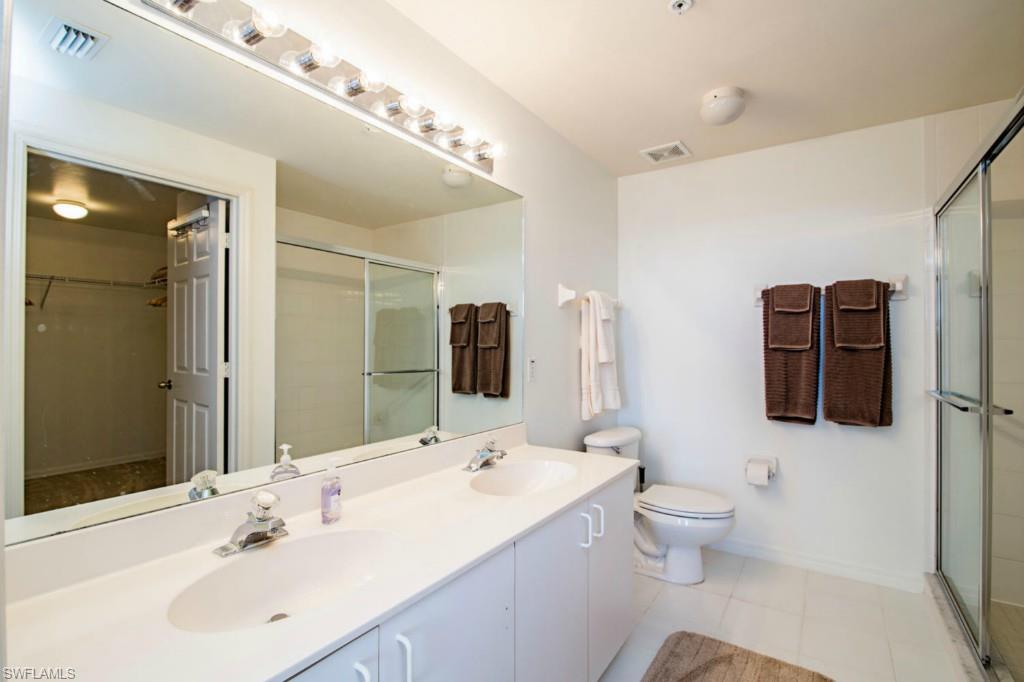 519 Roma Court, Unit 3301 Naples, FL 34110 - Photo 7 of 14 a bathroom with a double vanity sink and mirror
