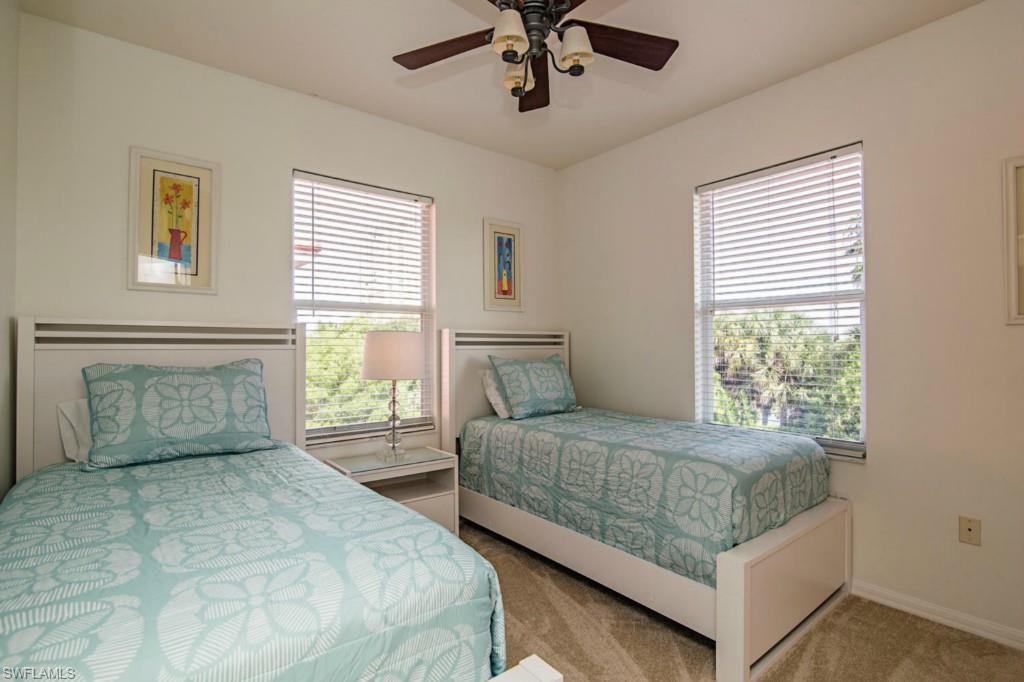 519 Roma Court, Unit 3301 Naples, FL 34110 - Photo 8 of 14 a bedroom with a large bed and a chandelier fan