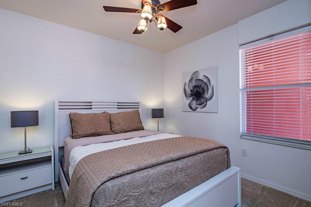 519 Roma Court, Unit 3301 Naples, FL 34110 - Photo 10 of 14 a bedroom with a bed and a chandelier