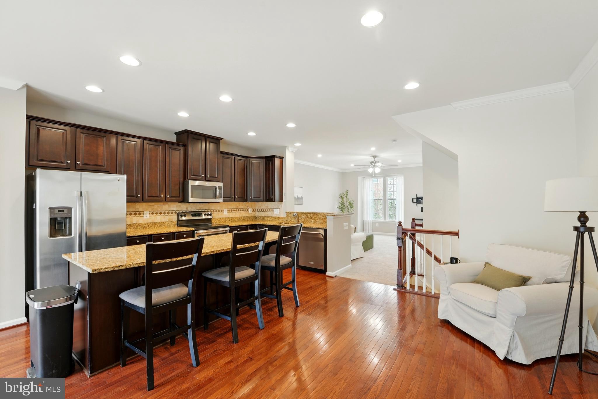 7054 Kona Drive Gainesville, VA 20155 - Photo 11 of 39 a living room with stainless steel appliances furniture and wooden floor