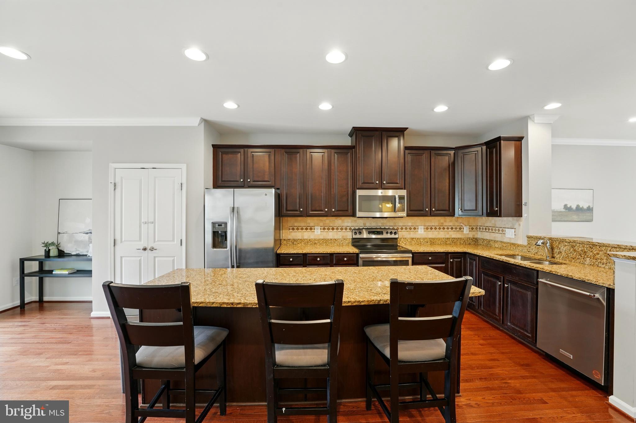 7054 Kona Drive Gainesville, VA 20155 - Photo 15 of 39 a large kitchen with a table and chairs