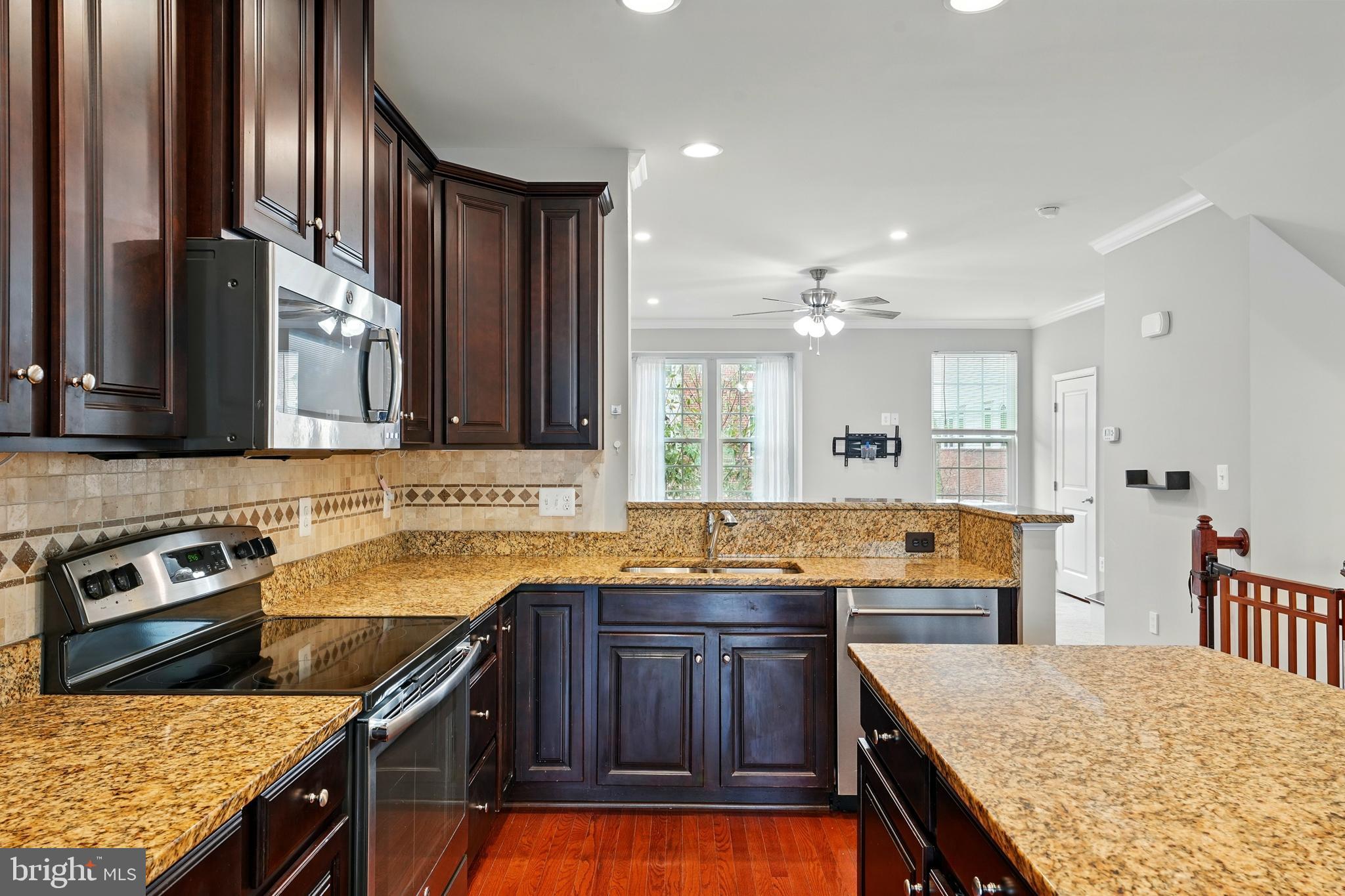 7054 Kona Drive Gainesville, VA 20155 - Photo 16 of 39 a kitchen with stainless steel appliances granite countertop a sink and stove