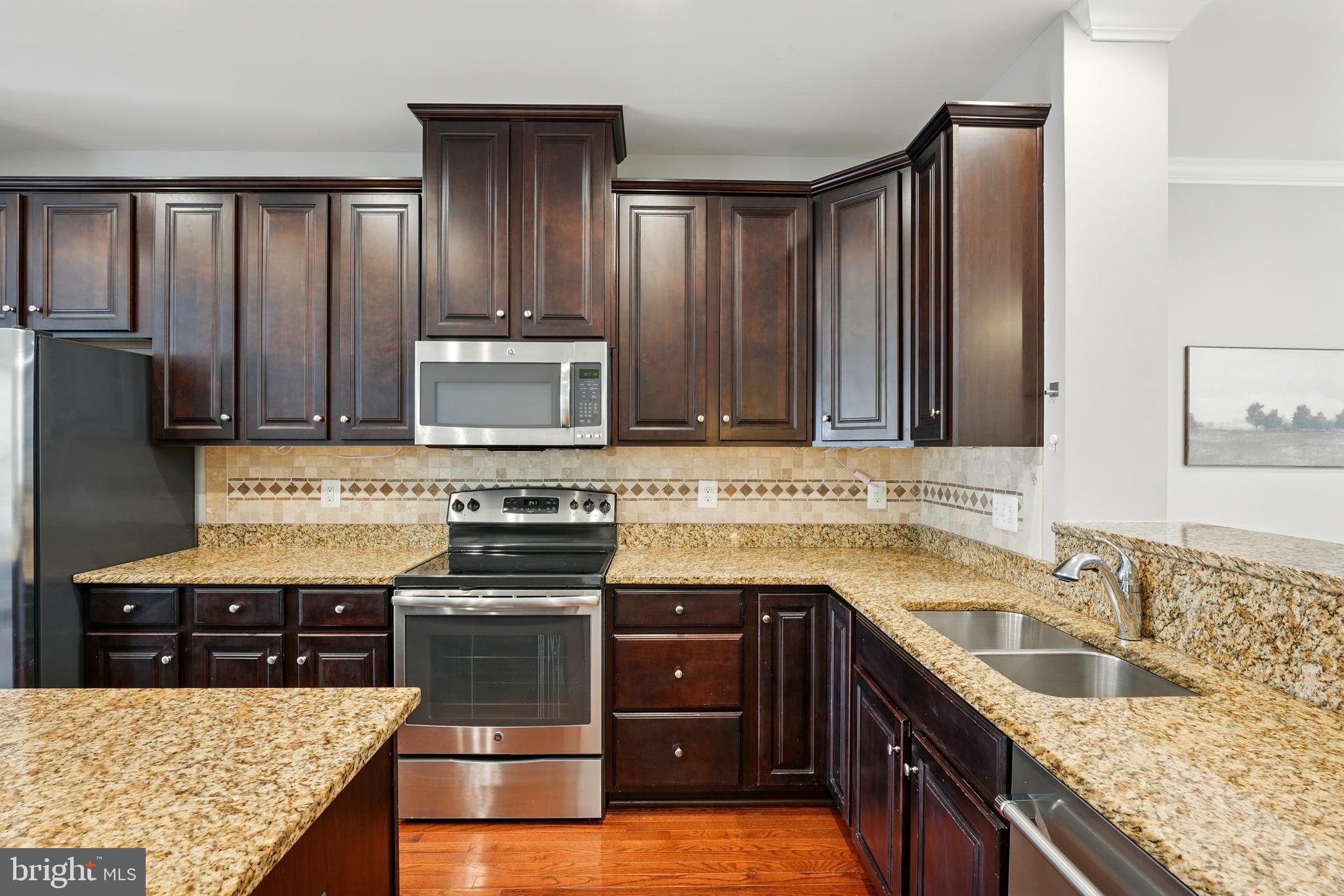 7054 Kona Drive Gainesville, VA 20155 - Photo 17 of 39 a kitchen with stainless steel appliances granite countertop a stove microwave and refrigerator