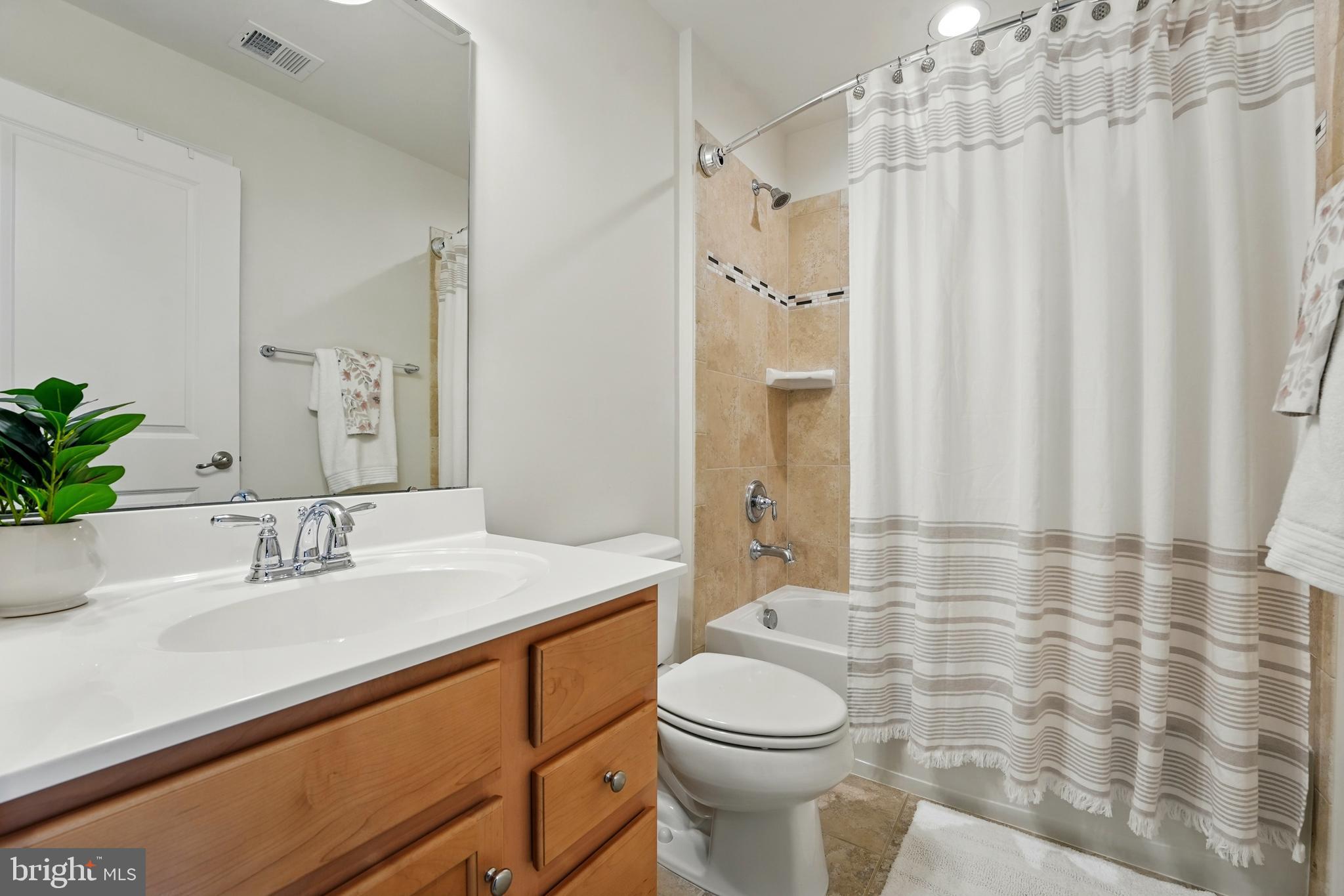 7054 Kona Drive Gainesville, VA 20155 - Photo 23 of 39 a bathroom with a sink a toilet and shower