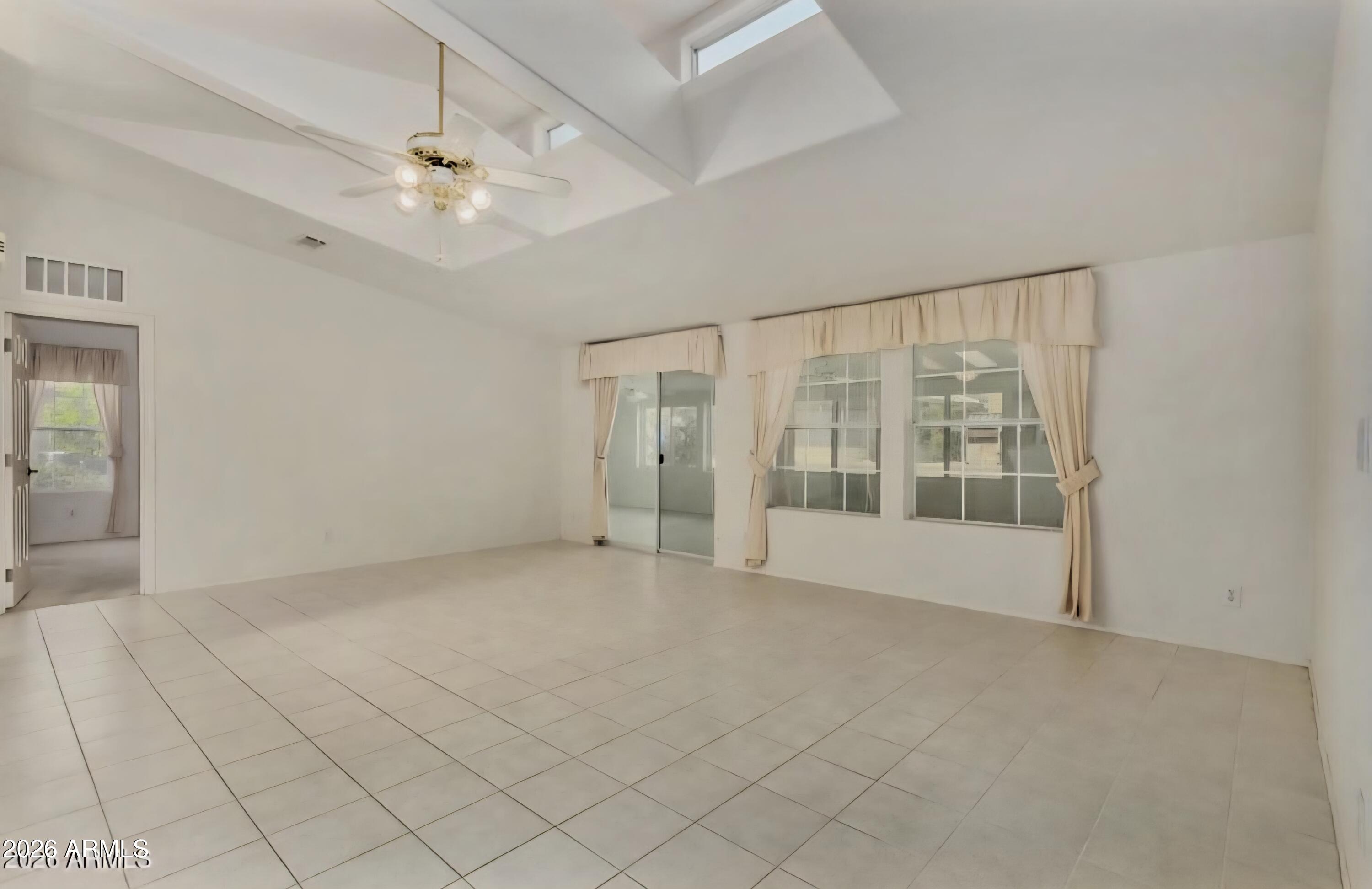 3301 South Goldfield Road, Unit 3004 Apache Junction, AZ 85119 - Photo 6 of 67 an empty room with chandelier fan and windows