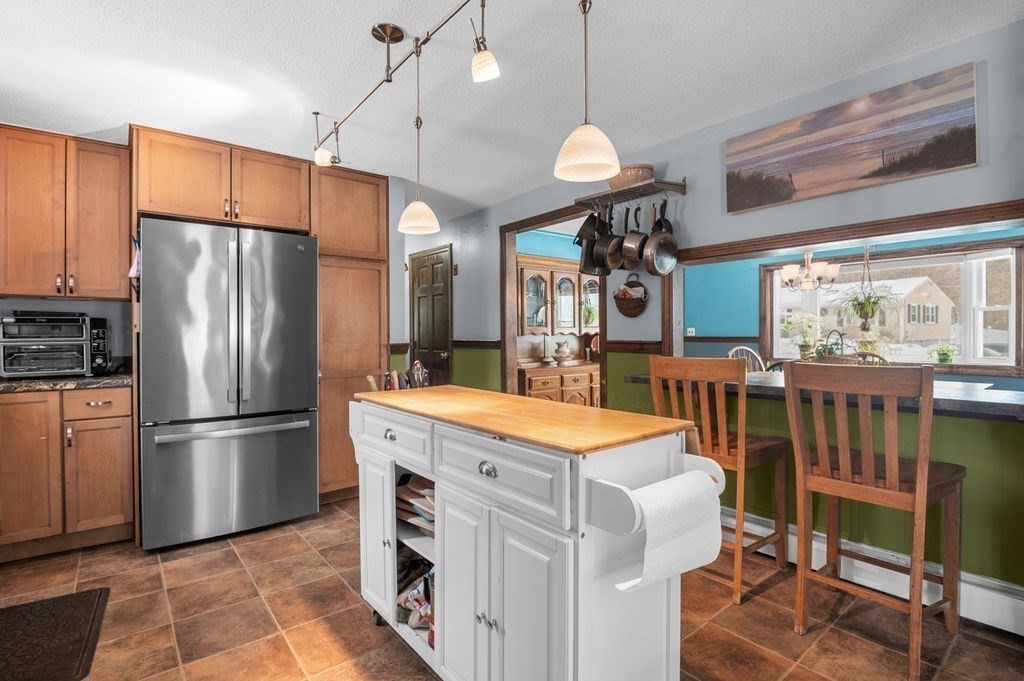 53 Birch Meadow Road Merrimac, MA 01860 - Photo 8 of 38 a kitchen with stainless steel appliances kitchen island granite countertop a refrigerator a stove a sink and a dining table with wooden floor