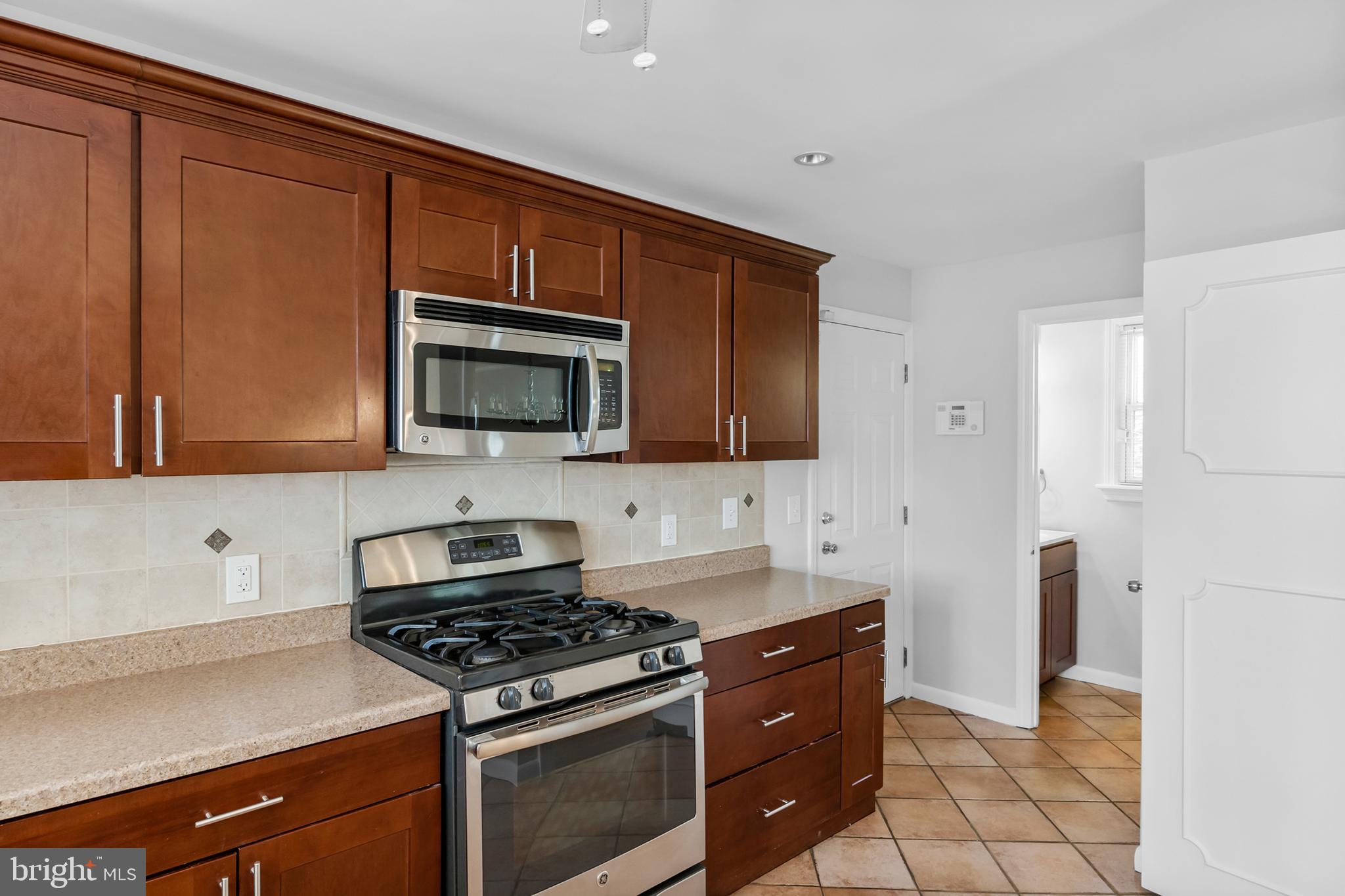 104 Sharrowvale Road Cherry Hill, NJ 08034 - Photo 19 of 37 a kitchen with stainless steel appliances a stove a microwave and cabinets