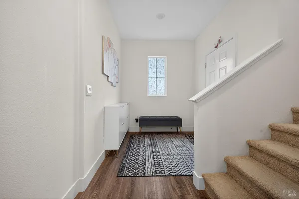 a bedroom with wooden floor and a rug
