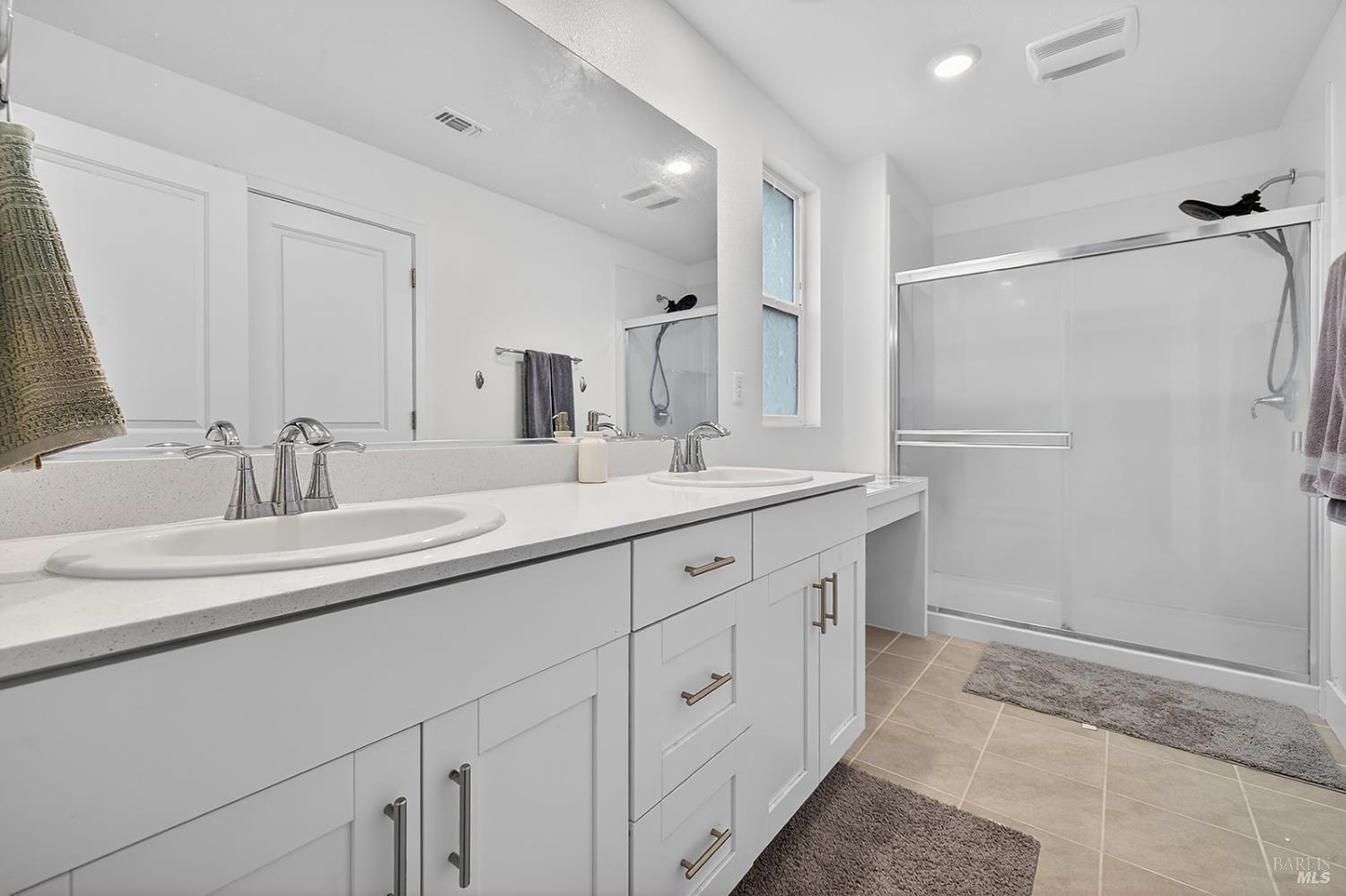 6042 Oxford Place Rohnert Park, CA 94928 - Photo 13 of 31 a bathroom with a double vanity sink a mirror and a shower