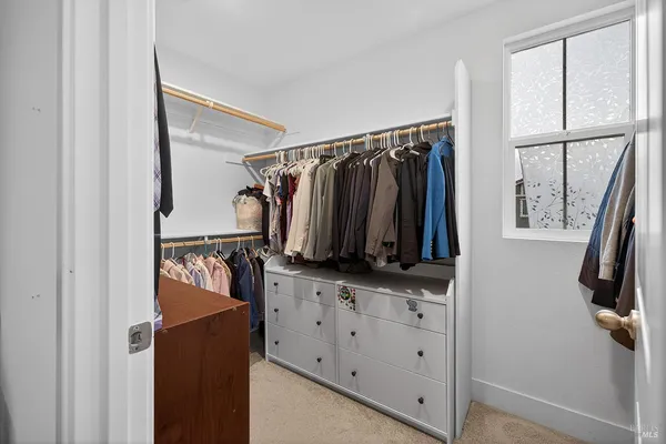 a view of walk in closet with clothes