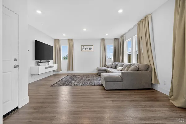 a living room with furniture wooden floor and a flat screen tv