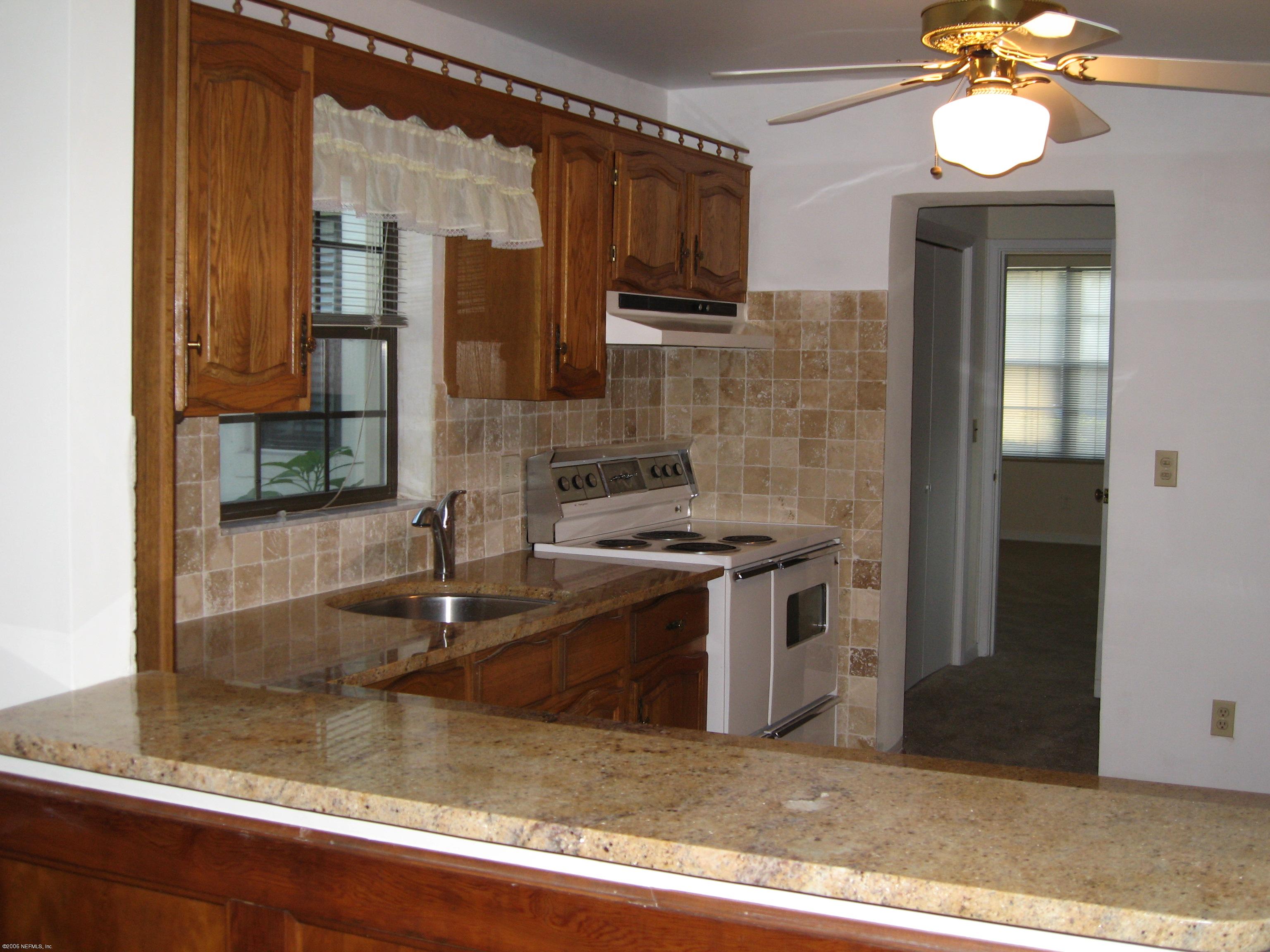 6139 Suwanee Road Jacksonville, FL 32217 - Photo 8 of 10 a kitchen with stainless steel appliances granite countertop a sink stove and cabinets