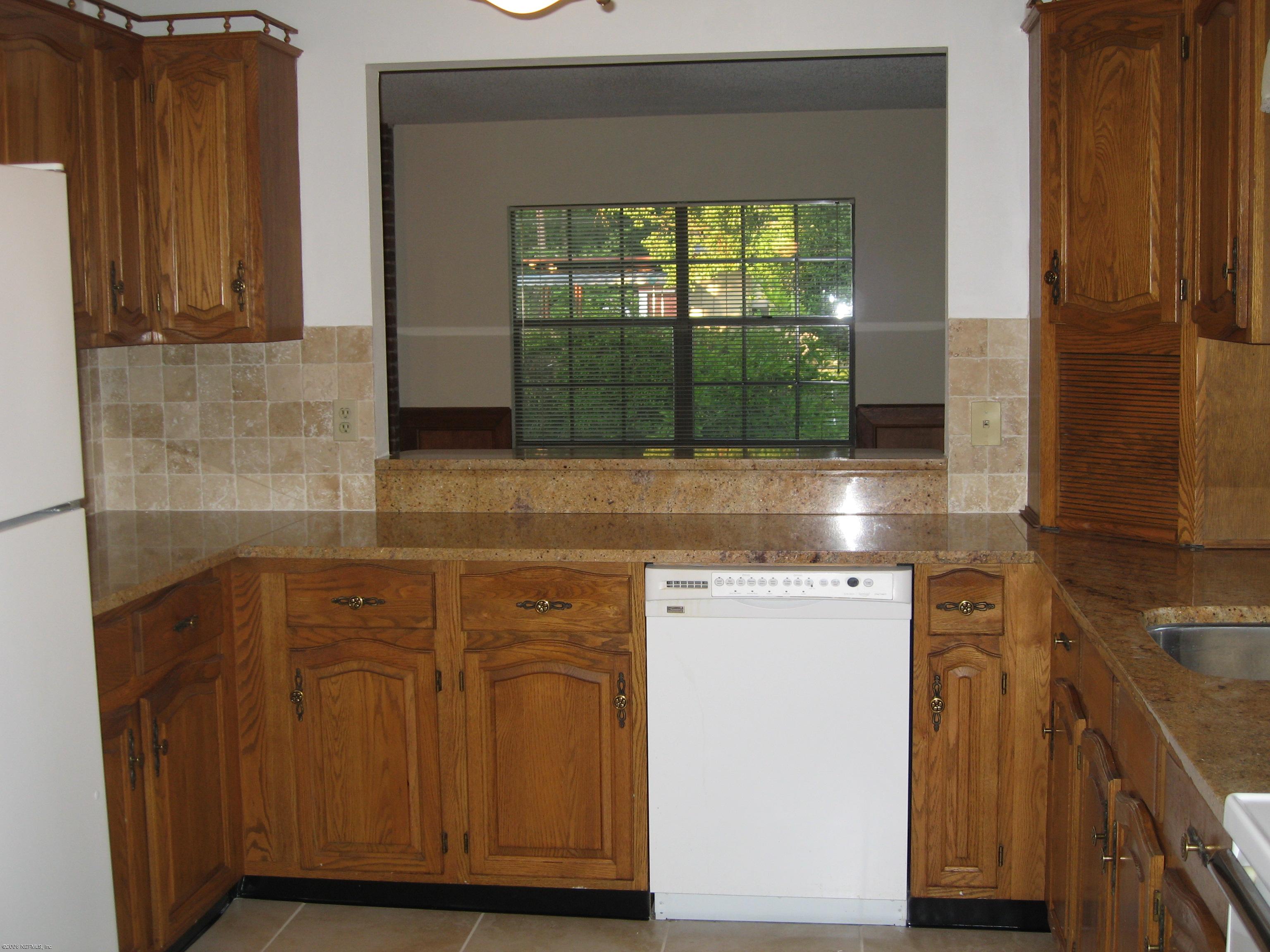 6139 Suwanee Road Jacksonville, FL 32217 - Photo 9 of 10 a kitchen with a sink and wooden cabinets