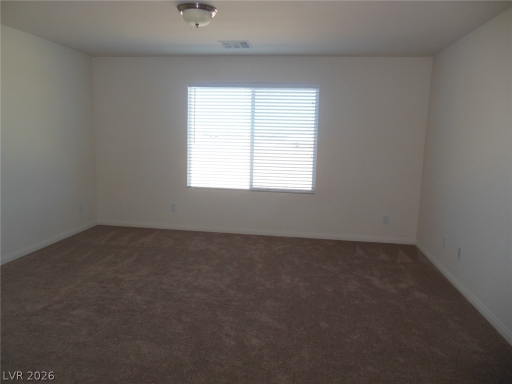 6390 Jackson Spring Road Las Vegas, NV 89118 - Photo 5 of 27 A well-lit, neutral-toned room features clean lines and comfortable carpeting.