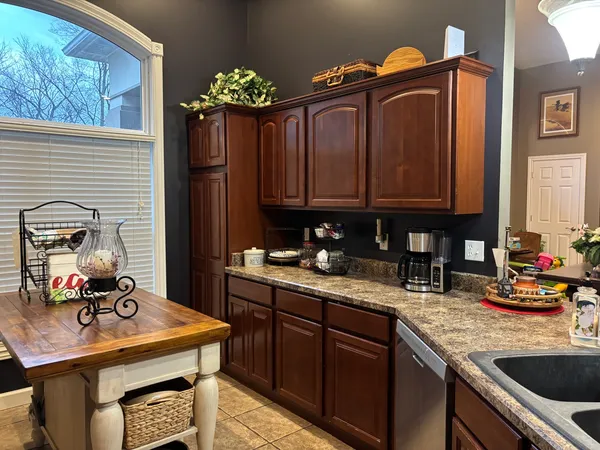 a kitchen with granite countertop a sink stove and cabinets