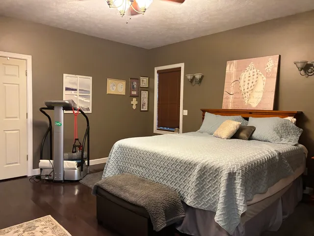 a bedroom with bed and wooden floor