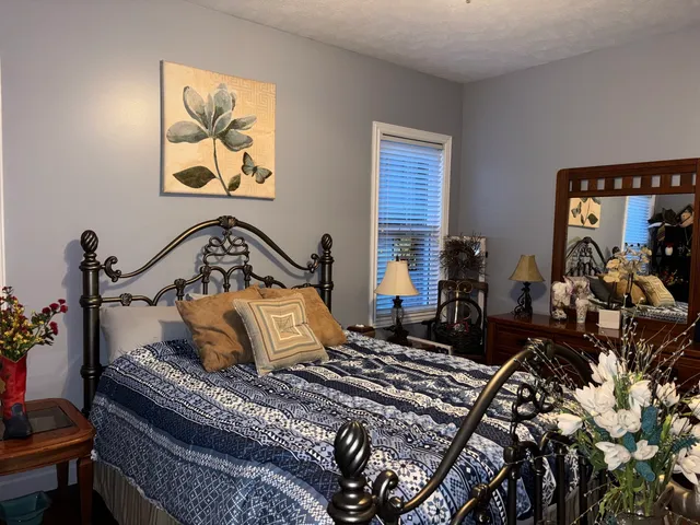 a bedroom with bed and wooden floor