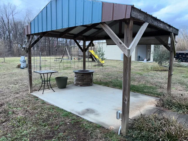 a view of a house with backyard and sitting area