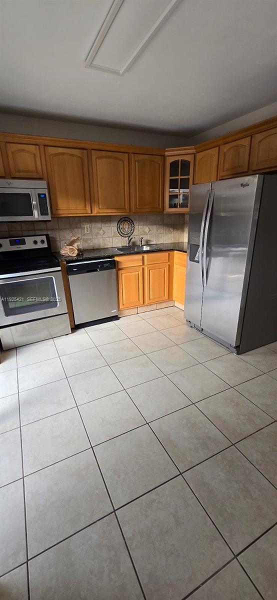 a kitchen with granite countertop a refrigerator and a stove top oven