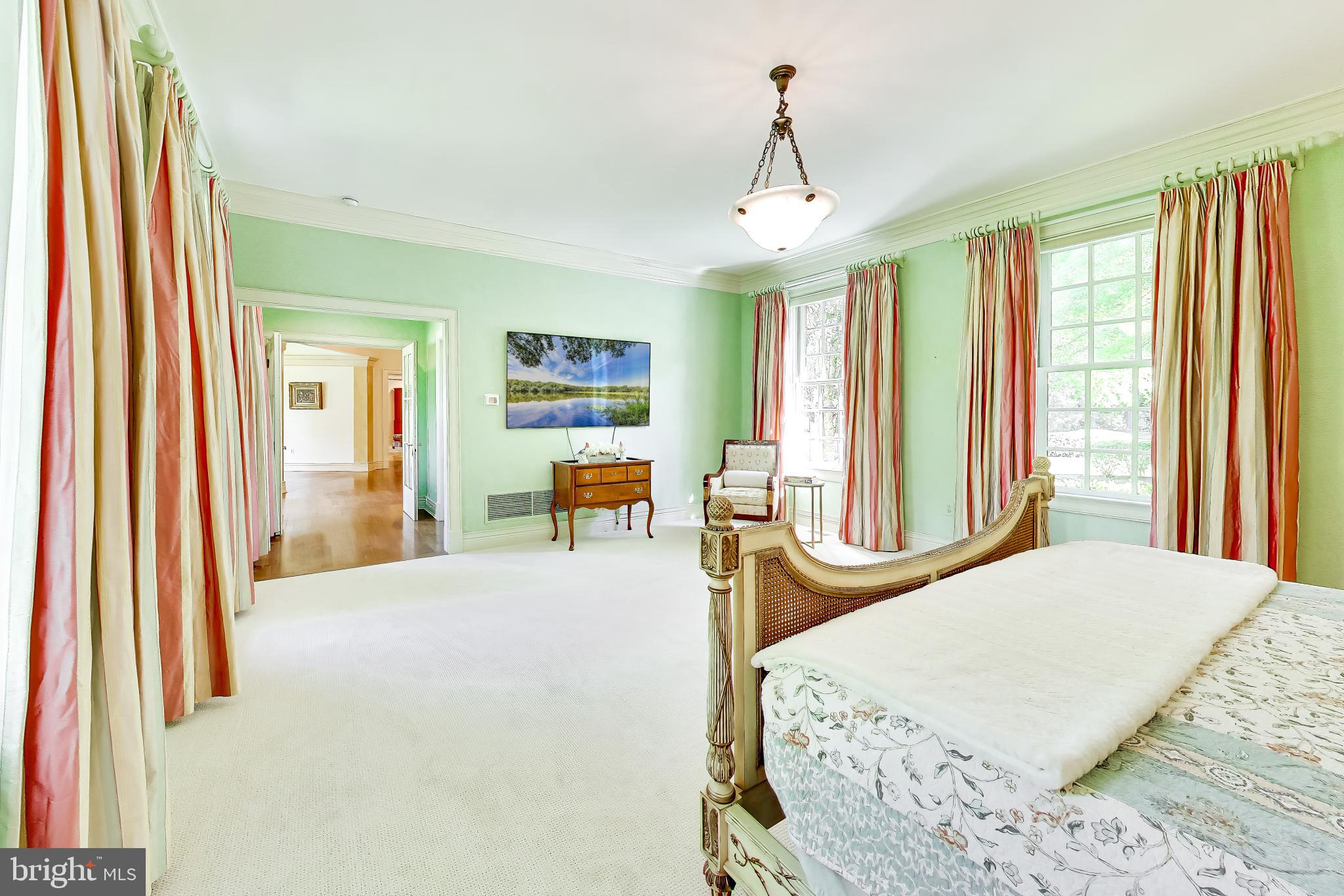 9001 Persimmon Tree Road Potomac, MD 20854 - Photo 29 of 77 a spacious bedroom with a bed and large windows