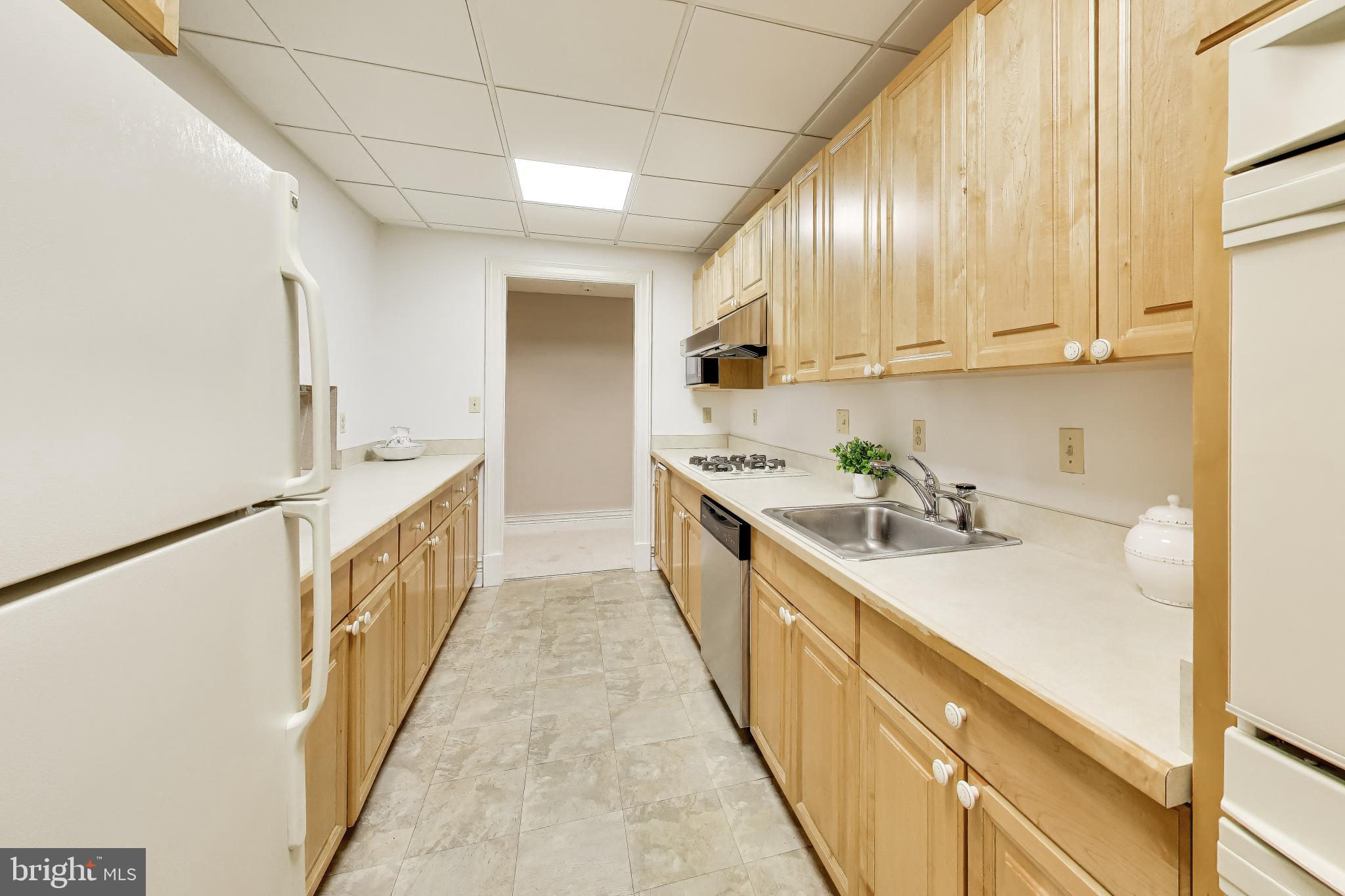 9001 Persimmon Tree Road Potomac, MD 20854 - Photo 64 of 77 a kitchen with cabinets a sink and appliances