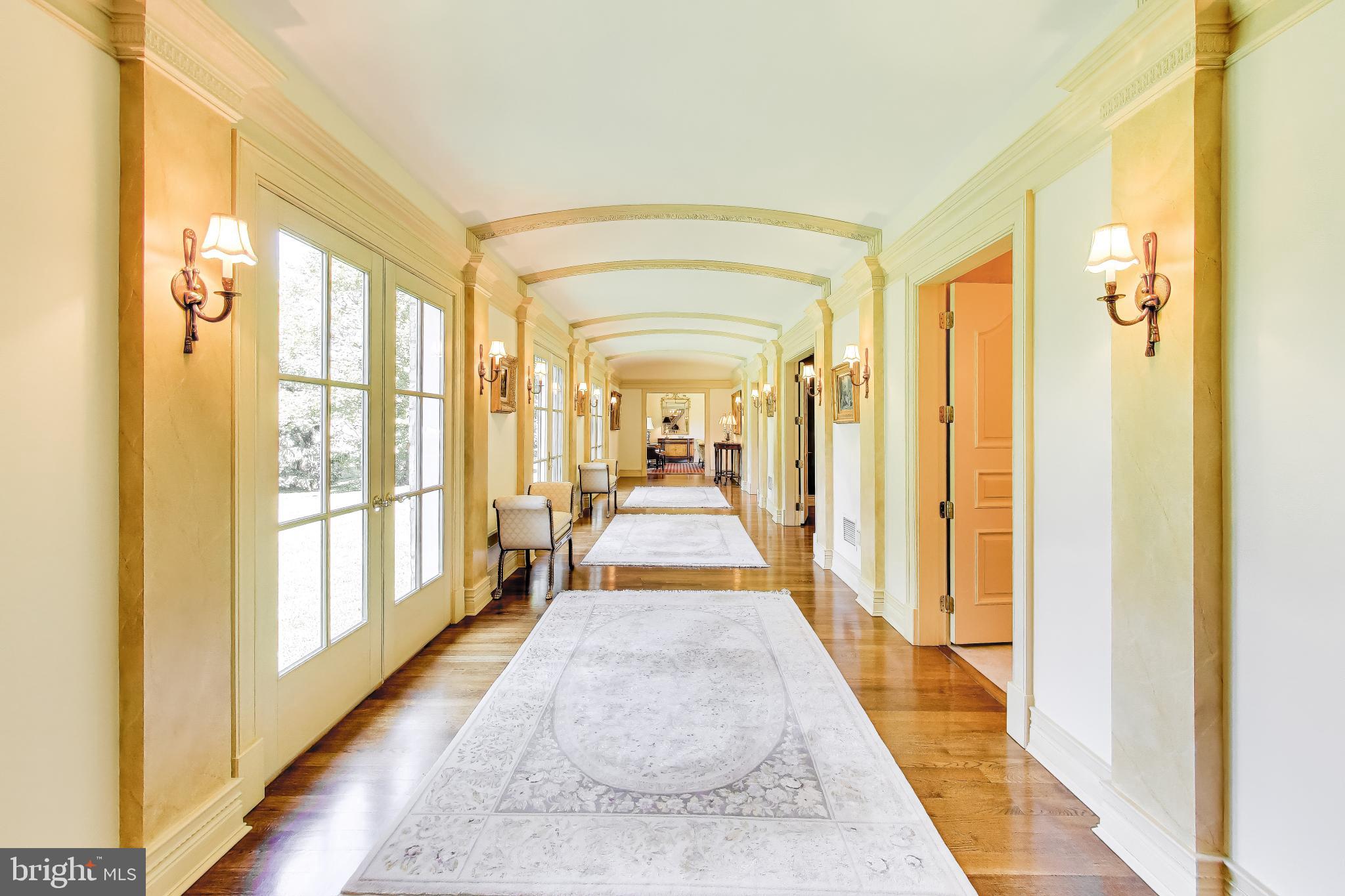9001 Persimmon Tree Road Potomac, MD 20854 - Photo 10 of 77 a view of a large room with wooden floor and windows