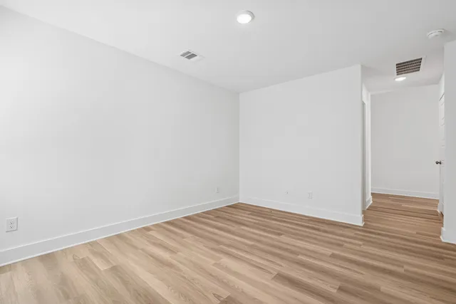 a view of large kitchen with wooden floor and stainless steel appliances