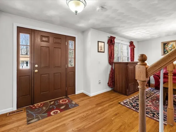 a living room with furniture a lamp paintings and a window