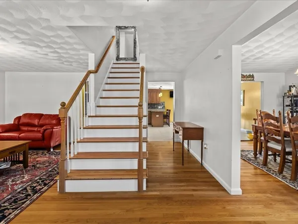 a view of a livingroom with wooden floor and stairs