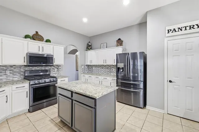 a kitchen with stainless steel appliances granite countertop a sink stove and cabinets